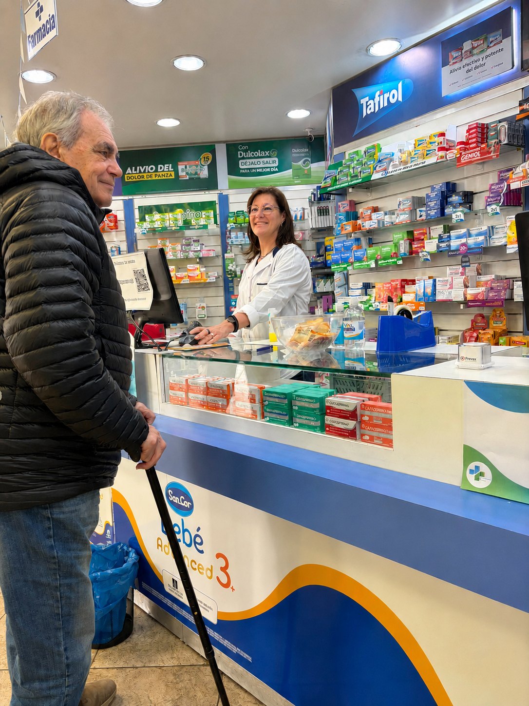 Farmacéutica de Farmacia Añon atendiendo a un cliente en el mostrador del local